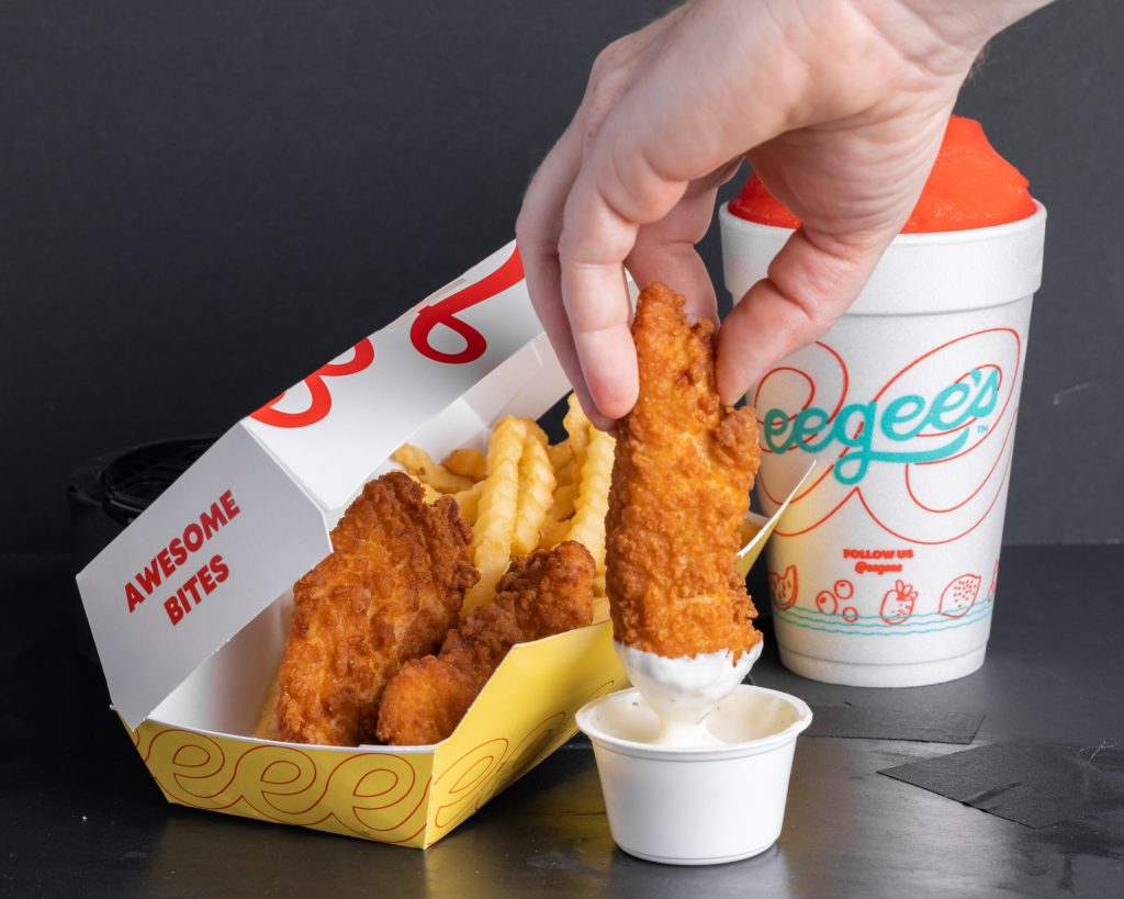 hand dipping chicken tender into ranch